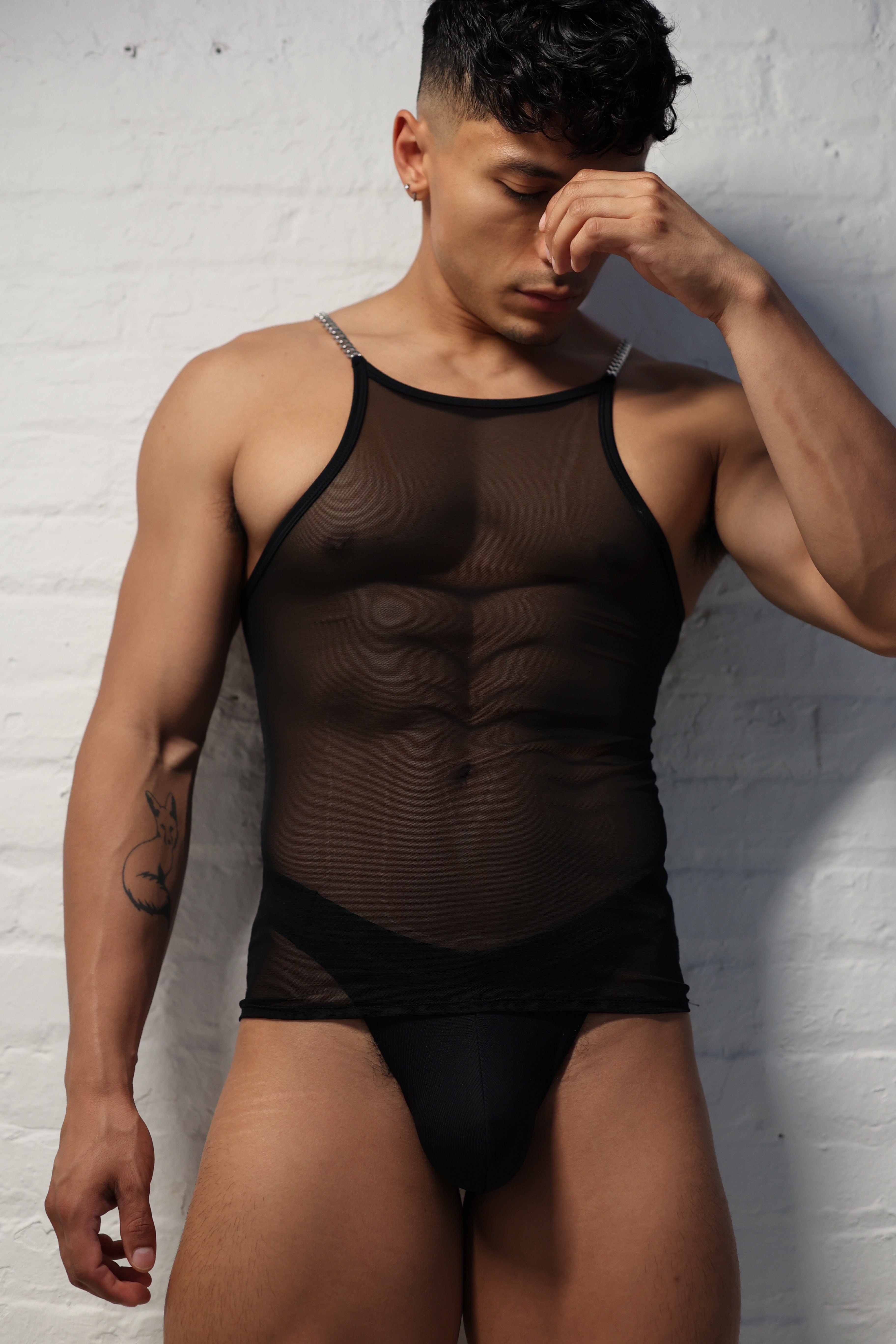 Model wearing black sheer mesh tank top with metal chain straps from Fabian Divani Studio mens collection