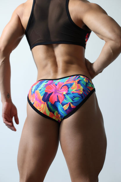 Fabian Divani modeling a sheer floral mesh crop top and swim brief set—handmade by Fabi —posed in front of a white wall