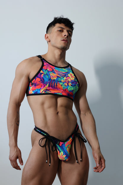 Fabian Divani modeling a sheer floral mesh crop top and swim brief set—handmade by Fabi —posed in front of a white wall
