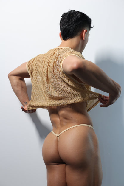 Fabian Divani modeling a sheer natural mesh crop top and G-string underwear set— handmade men's underwear — posed in front of a white wall