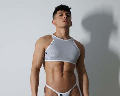 Fabian Divani modeling a sheer  pinstripe mesh crop top and G-string underwear set— handmade men's underwear — posed in front of a white wall