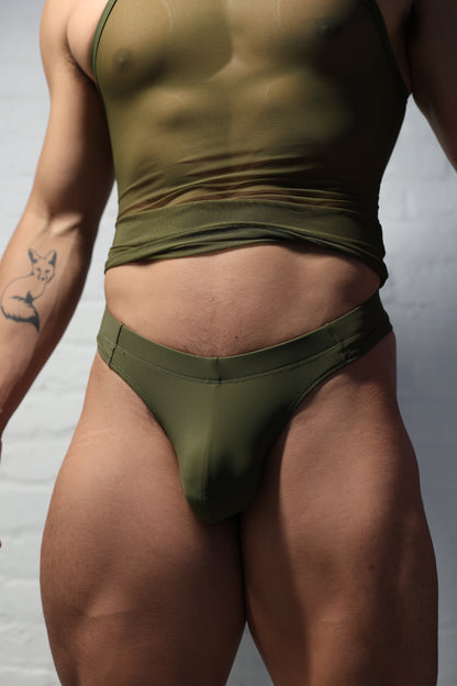 Model wearing olive green men's thong underwear from Fabian Divani vers collection showing minimal coverage and military-inspired color