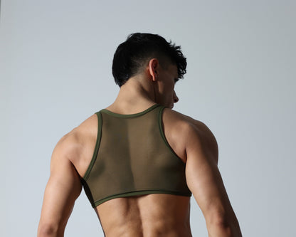 Fabian Divani modeling a sheer olive green mesh crop top—handmade by Fabi —posed in front of a white wall